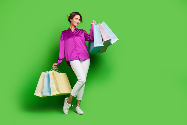 迷人的华丽的女孩走商场时髦的服装服装空空间孤立的绿色背景的全身照片图片下载