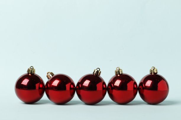在蓝色背景上排成一排的红色圣诞球。放文字的地方。图片下载