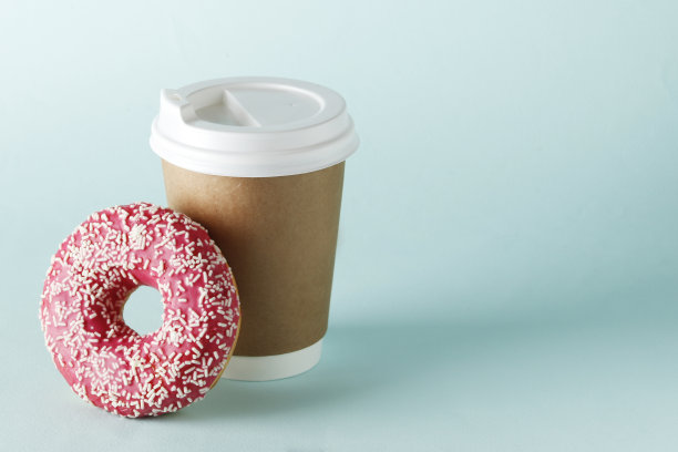 杯子里有咖啡和甜甜圈，蓝色的背景上有文字的地方。图片下载