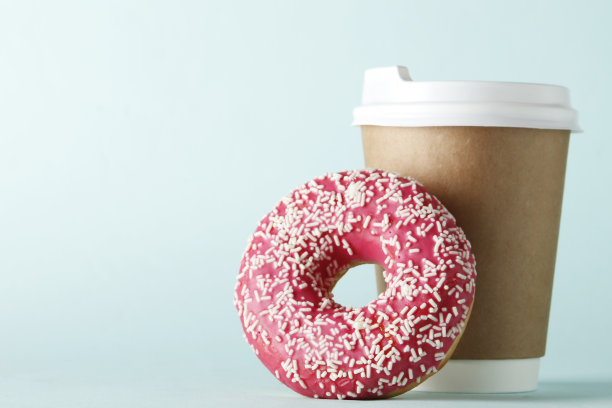 杯子里有咖啡和甜甜圈，蓝色的背景上有文字的地方。图片下载