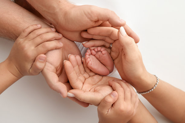 孩子的脚在妈妈手里，在爸爸手里，在父母手里。一个小新生儿的脚特写。小婴儿的腿。妈妈和她的孩子。幸福家庭概念。美丽的概念形象的母性股票照片。图片下载