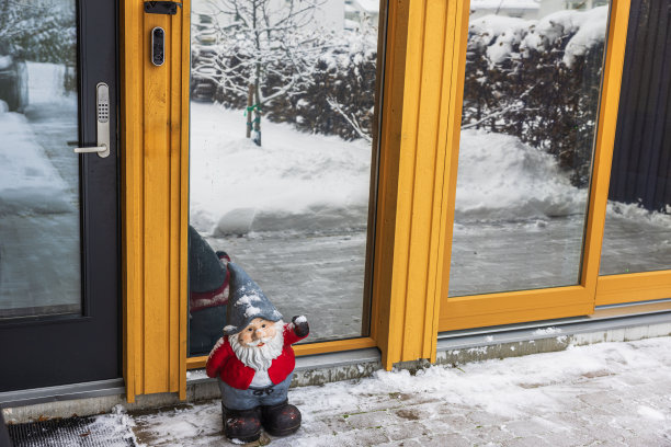 在寒冷的冬日，圣诞老人站在别墅门口的迷人景象。图片下载