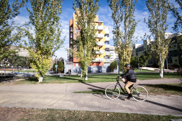 一个小女孩骑着自行车穿过住宅区去上班图片下载
