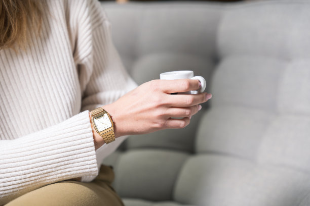 一个女人的手与手表和咖啡杯的特写-照片图片下载