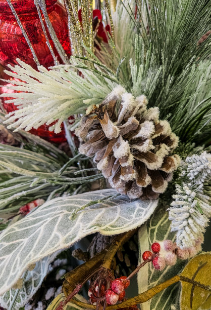 背景照片，冬天的松果和松树的树枝覆盖着红色的装饰品和冬青浆果的雪图片下载