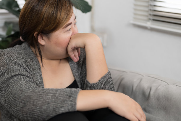 悲伤超重的女人在沙发上思考问题，沮丧的女孩因为糟糕的关系而感到孤独和悲伤，抑郁的女人精神健康失调。图片下载