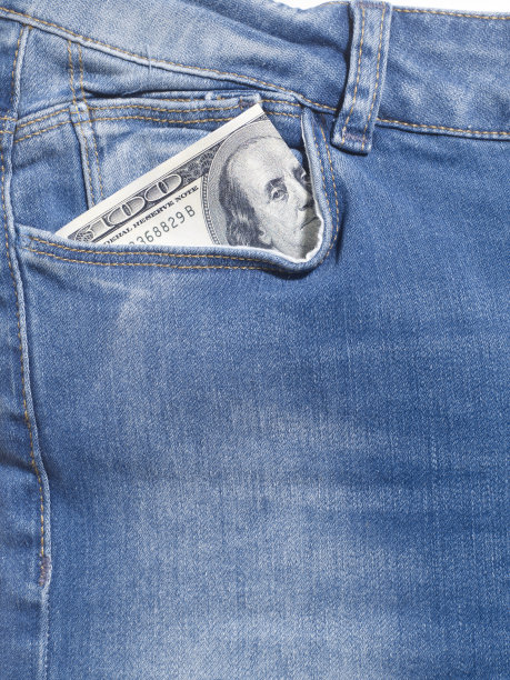 特写牛仔裤细节照片在工作室。你的牛仔裤口袋里有100美元。没有人。图片下载