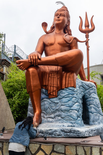 清晨，小女孩从平角向印度教湿婆神雕像致敬图片下载