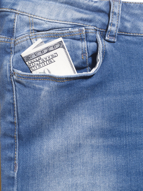 特写牛仔裤细节照片在工作室。你的牛仔裤口袋里有100美元。没有人。图片下载