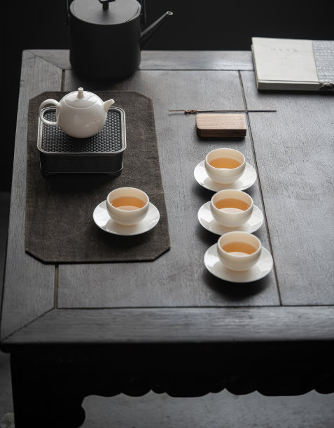 手正从水壶里倒茶到桌上的茶杯里，茶的形象雇佣了照片图片下载