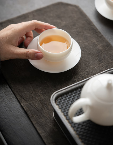 手正从水壶里倒茶到桌上的茶杯里，茶的形象雇佣了照片图片下载