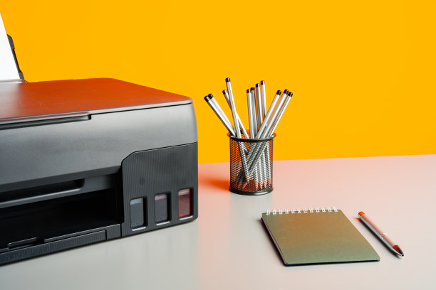 桌子上的激光打印机，黄色背景。图片下载