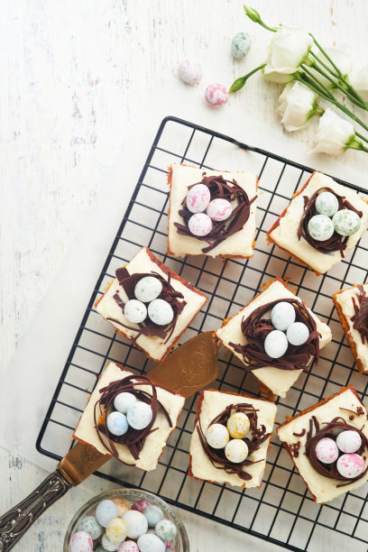 复活节胡萝卜蛋糕棒装饰巧克力窝和巧克力糖蛋开花樱桃或苹果花在乡村轻木制背景。复活节的节日大餐。传统的复活节食物。图片下载