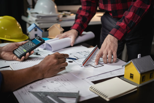 建筑工程师用工程工具和房地产中住宅或办公楼的建筑理念来绘制蓝图，建造大型商业建筑。特写照片图片下载