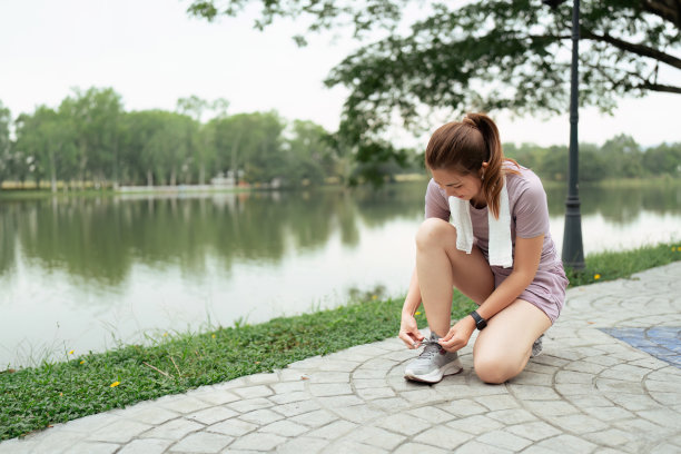 活跃的早晨。一个穿着运动服的女人在跑步前系鞋带的特写照片图片下载