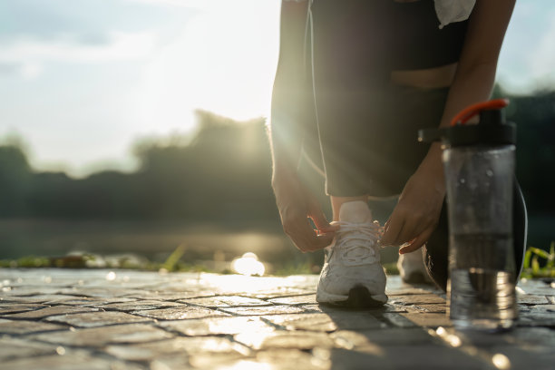 活跃的早晨。一个穿着运动服的女人在跑步前系鞋带的特写照片图片下载