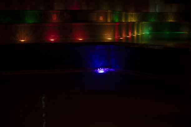 照明喷泉。LED灯在水面上闪闪发光。喷泉在多色照明。图片下载