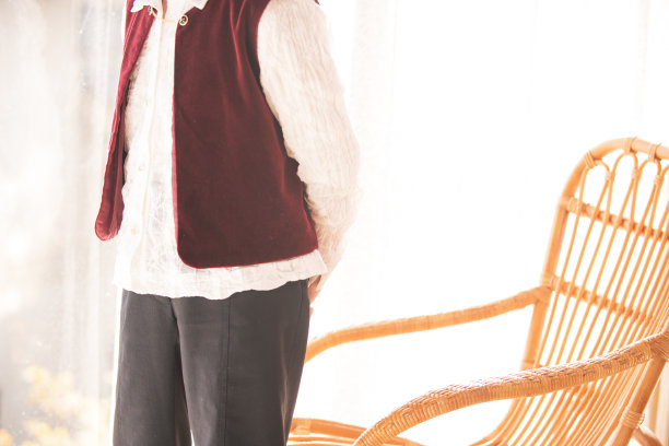 一位年长的女士站在藤椅上向外看图片下载