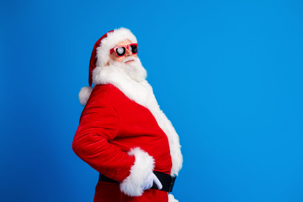 老人的照片肖像触摸带促销折扣穿着时尚的圣诞老人服装外套孤立的蓝色背景图片下载