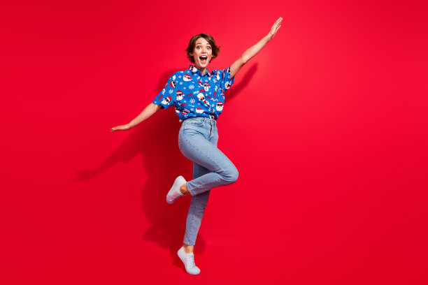 飞行的年轻女孩举起手臂的全身照片，促销横幅准备商场销售圣诞派对孤立的红色背景图片下载