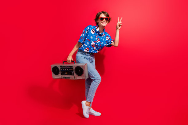 立体声音乐播放器老式录音机的全身照片显示v标志你好符号年轻女孩新年dj孤立的红色背景图片下载