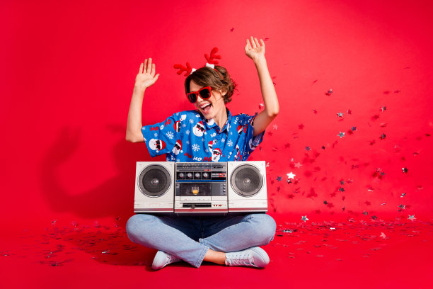 全身照片坐唱歌的女孩卡拉ok boombox派对新年迪斯科舞厅冬季假期闪闪发光滴孤立的红色背景图片下载