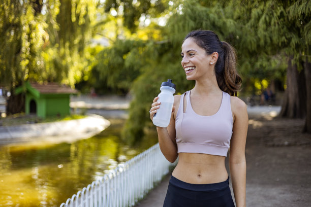年轻女子从瓶子里喝水的照片。图片下载