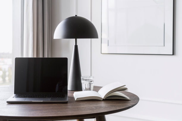 笔记本电脑，空显示屏放在工作台上，靠近台灯，打开书阅读图片下载