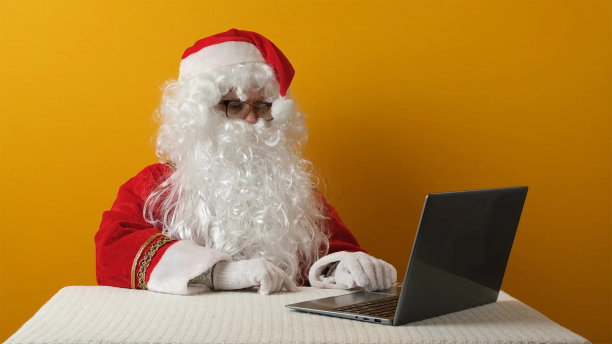 圣诞老人送钱美元和笔记本电脑。图片下载