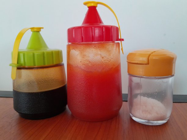 餐厅桌子上有几瓶番茄酱、酱油和盐。图片下载