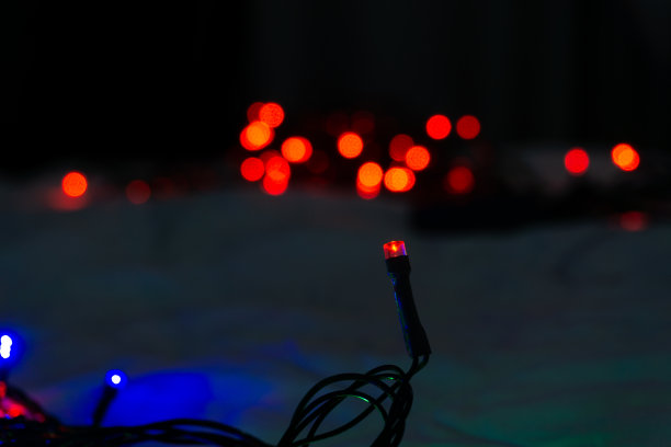 在黑暗的房间里，床上的红色圣诞彩灯图片下载