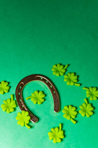带三叶草的幸运马蹄铁俯视图。在淡绿色背景上的圣帕特里克节概念图片下载