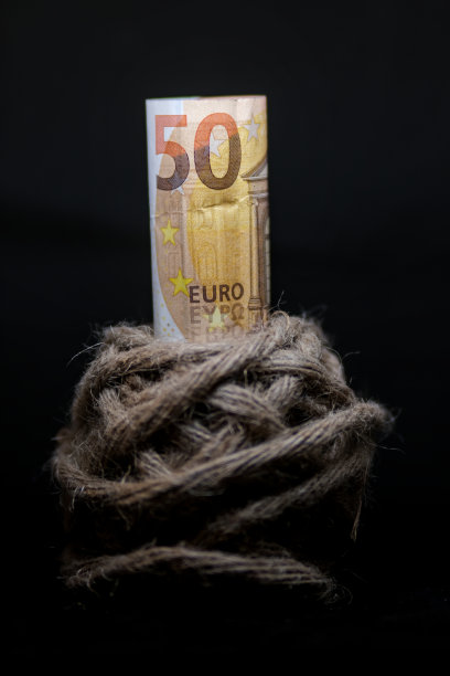 在黑色背景上，在麻麻线球上显示“时间”字的木制方块。图片下载