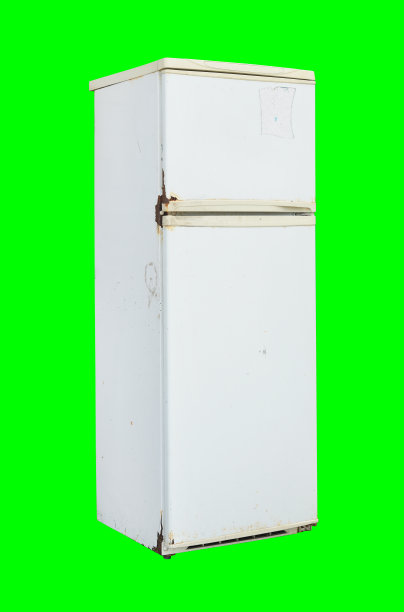 旧的生锈的冰箱孤立在绿色的背景上。图片下载