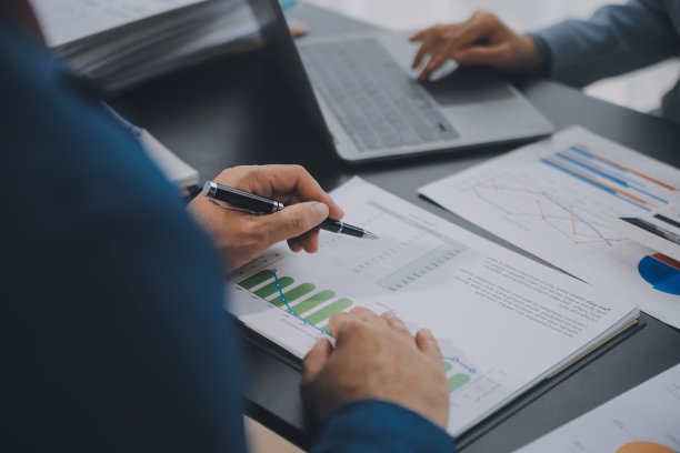 财务业务团队出席。商人手里拿的文件有金融统计、股票照片、讨论、分析报告数据的图表。财务概念图片下载