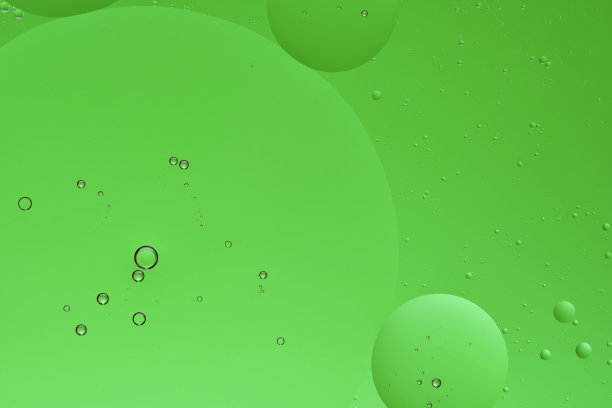 微距照片与圆形油滴水面。抽象的绿色背景与油泡沫。图片下载