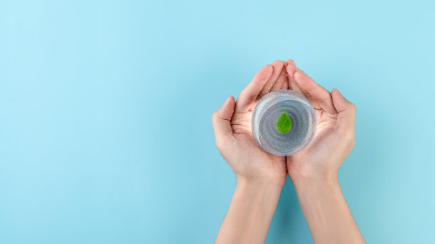 拿一个玻璃球，里面有水，上面有树叶，世界水日，节约用水，清洁可再生能源，防洪救灾的理念。图片下载