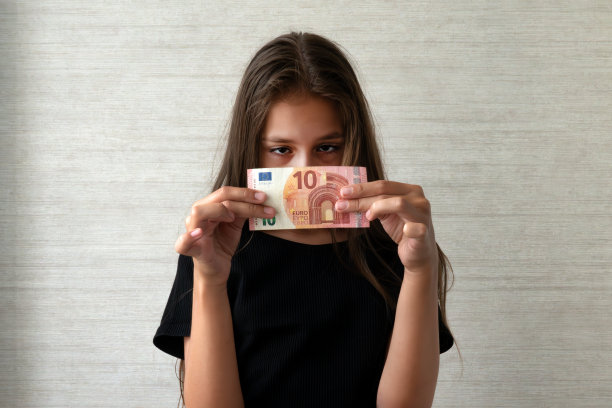 钱不够。悲伤的孩子带着十欧元的钱。白色背景图片下载
