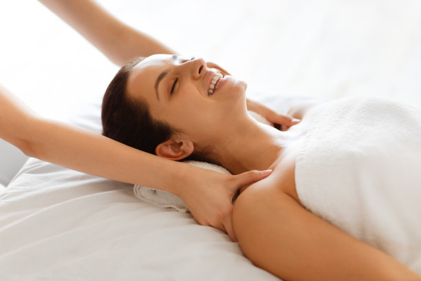 放松的女人在水疗沙龙接受肩部按摩图片下载