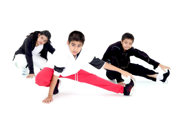 快乐的学生儿童小组在室内工作室教室里学习现代舞，孩子们，男孩和女孩，在白色的背景上跳舞。三个小舞者一起练习霹雳舞。图片下载