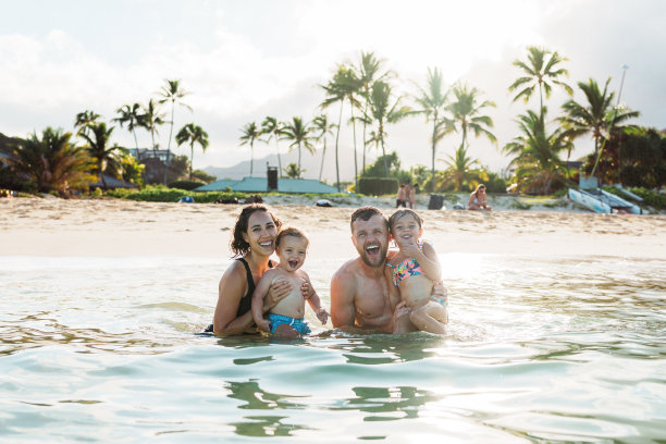 幸福的一家人在夏威夷海滩游泳的照片图片下载