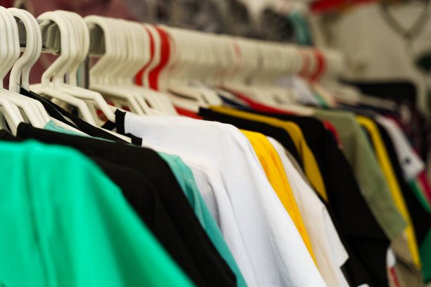 展会上，交易帐篷柜台上的衣架上挂着五颜六色的t恤。图片下载