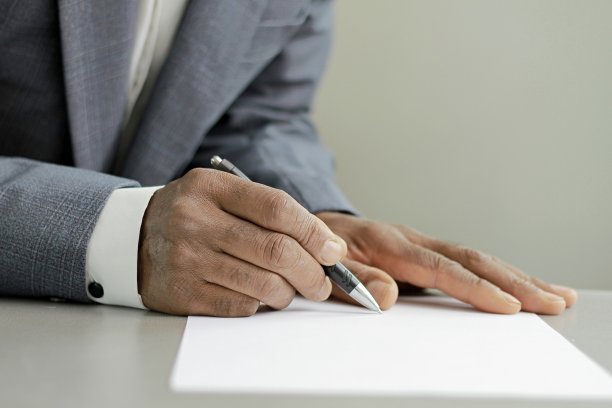 男子写字用笔在办公桌上与灰色背景的人股票图片股票照片图片下载