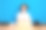 照片中迷人的女士坐在办公桌后面，用笔记本电脑微笑着看着蓝色背景上孤立的相机图片下载