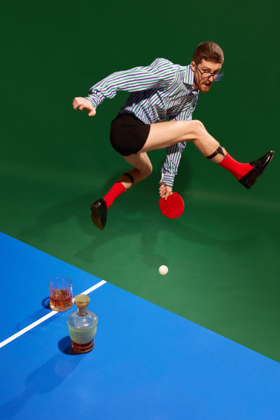 前视图。穿着衬衫和内衣的年轻人在行动。跳跃，打平板网球，在绿色背景下喝威士忌图片下载