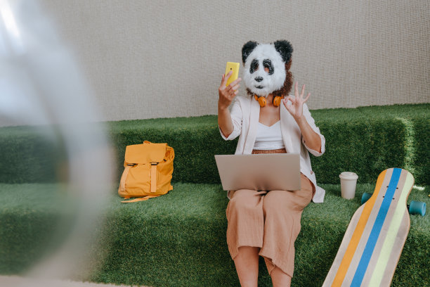 戴着熊猫面具的女商人在办公室的休息区工作图片下载