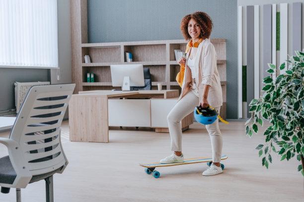 优雅的女商人穿着休闲装骑着滑板图片下载