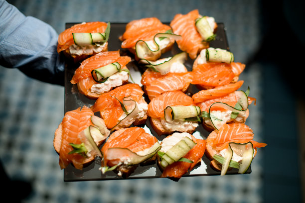 高质量的照片，意式烤面包与奶油奶酪，鲑鱼和黄瓜片在金属托盘上图片下载