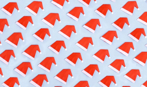 圣诞老人帽子的无缝图案在天空明亮的背景，圣诞快乐的愿望概念照片，完美的壁纸和背景图片下载