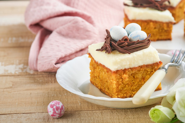 复活节胡萝卜蛋糕棒装饰巧克力窝和巧克力糖蛋开花樱桃或苹果花在乡村轻木制背景。复活节的节日大餐。传统的复活节食物。图片下载